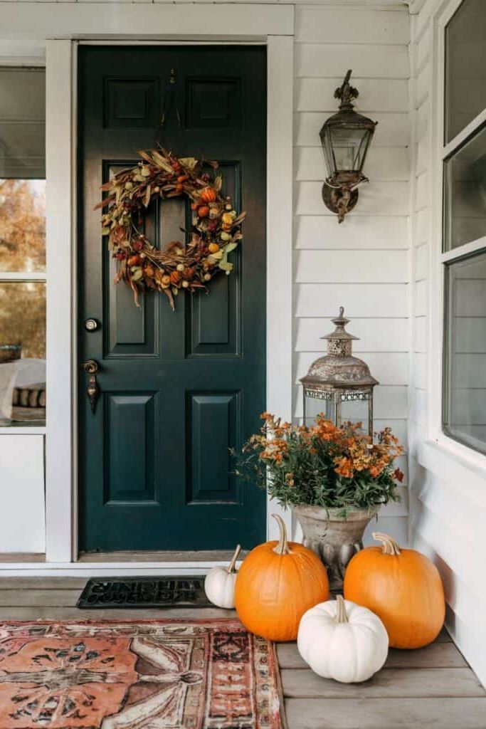 Fall porch with vintage lantern and sleek pumpkins