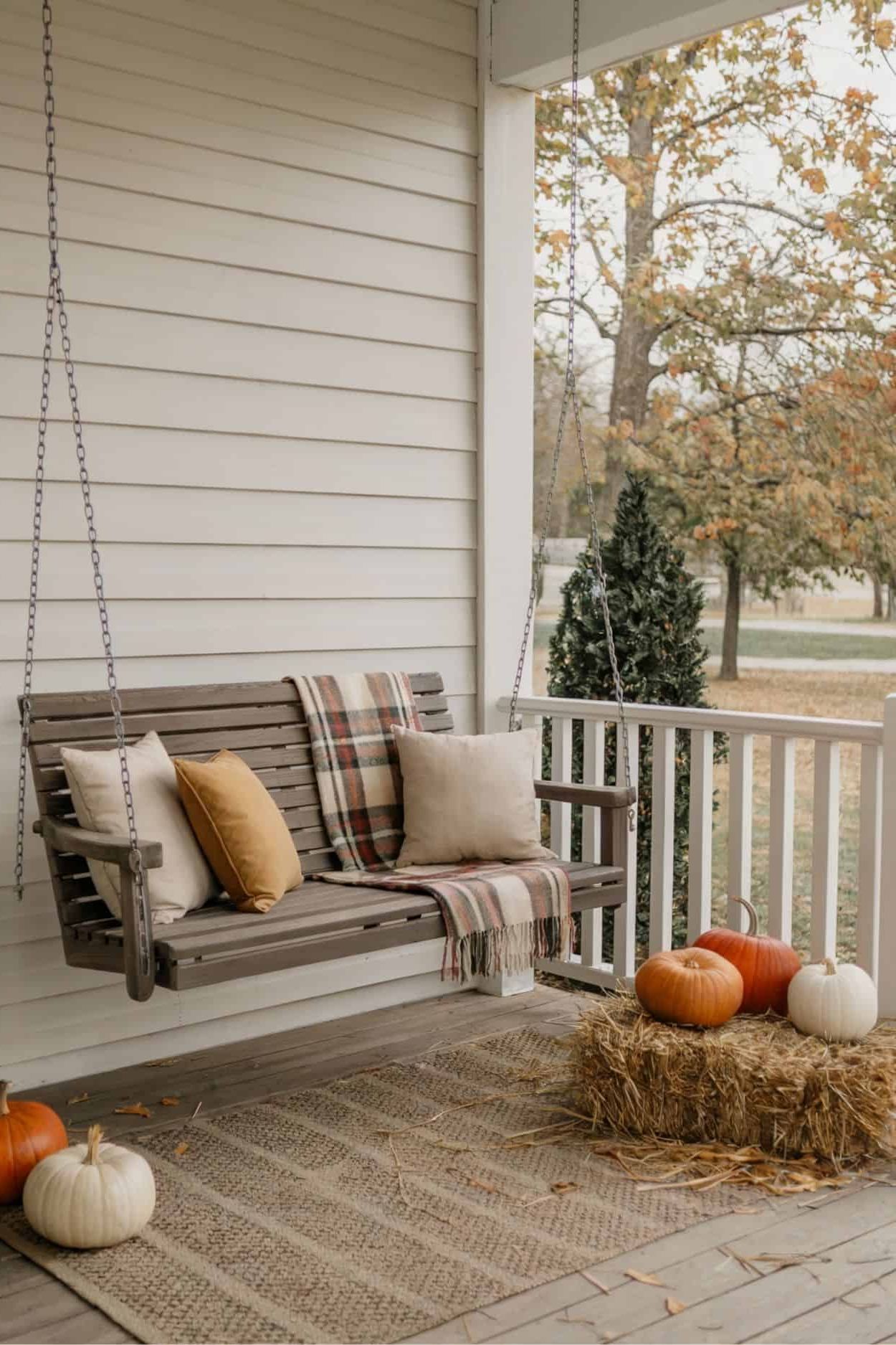 Neutral Porch Swing with Fall Pillows and Pumpkins