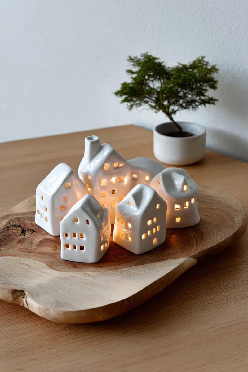 mini ceramic white houses with battery tea lights on a wooden tray 1