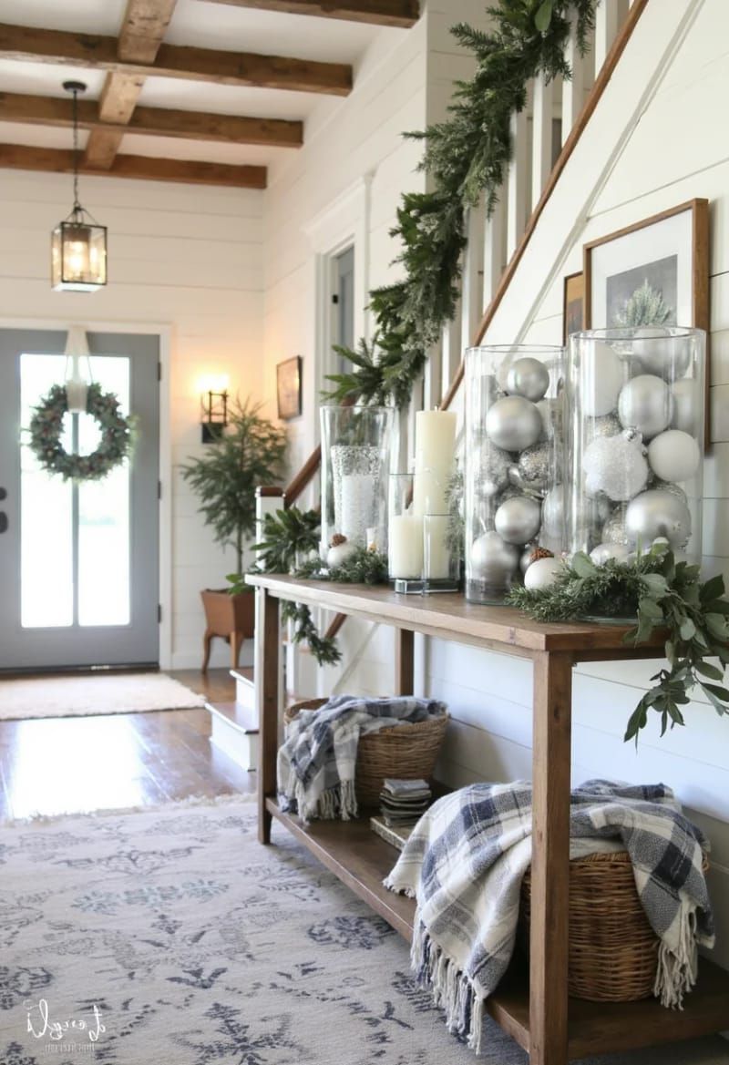 large glass vases filled with silver and white baubles on entryway tables 1