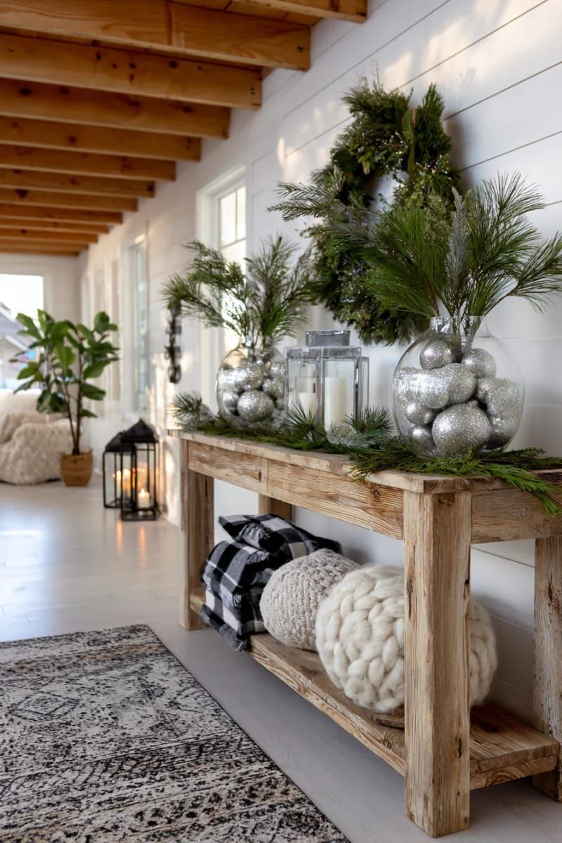 large glass vases filled with silver and white baubles on entryway tables 1