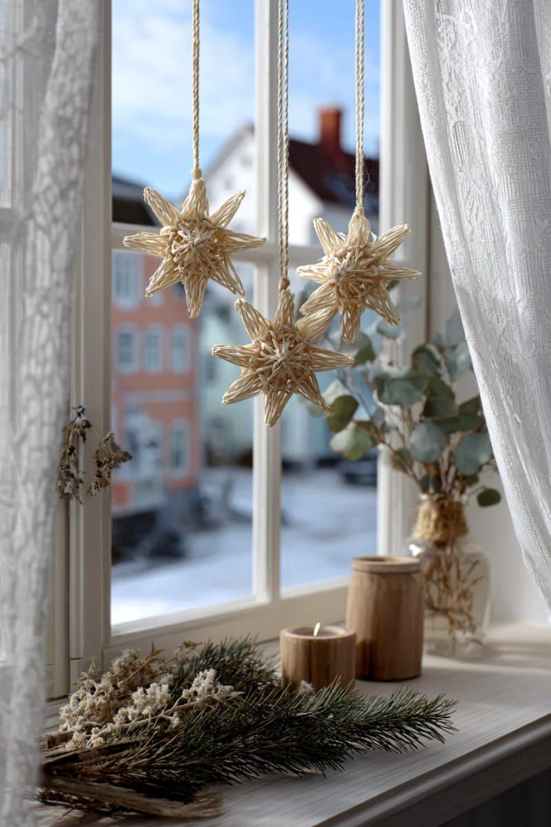 woven straw stars and bells hanging in the window 1