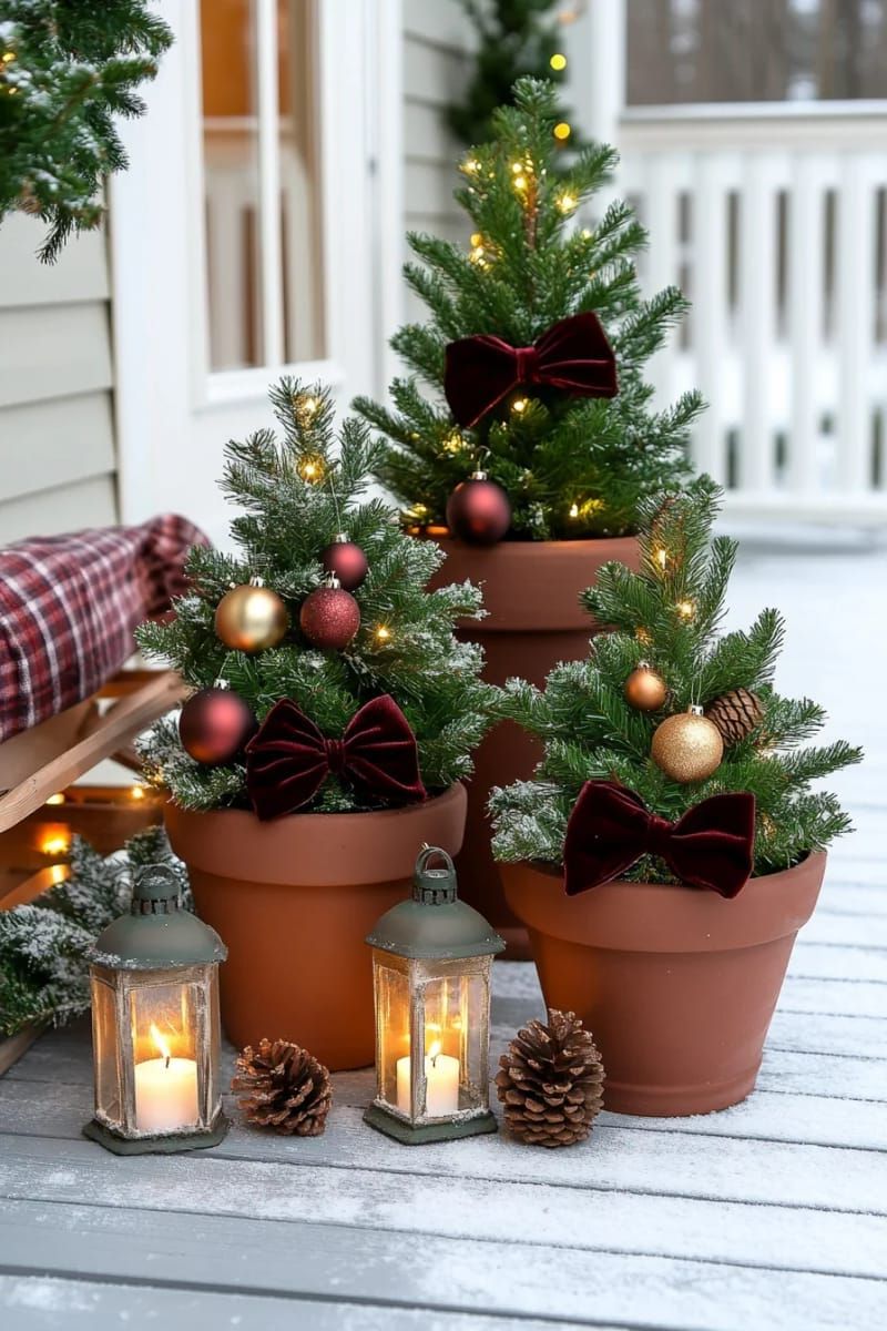 layered mini christmas trees in terracotta pots with velvet bows 1