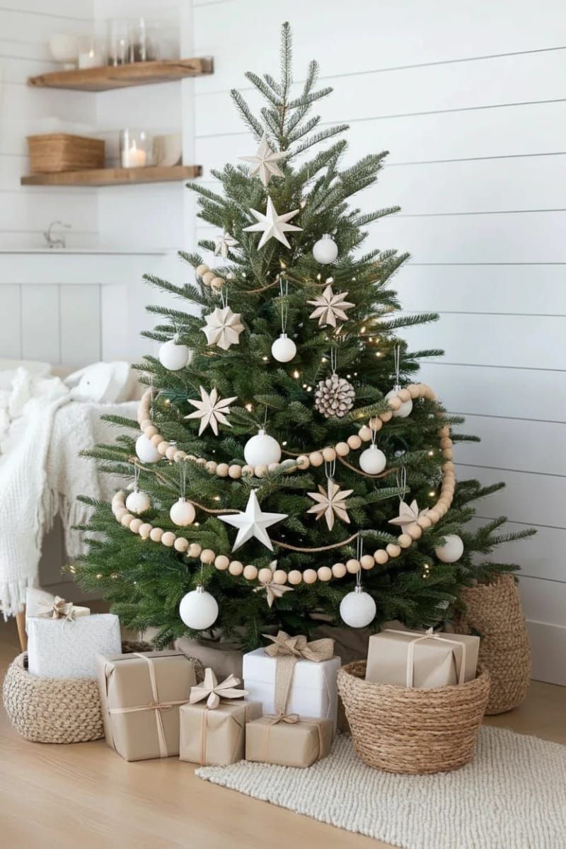 scandinavian style tree with white ornaments, paper stars, and natural wood garland 1