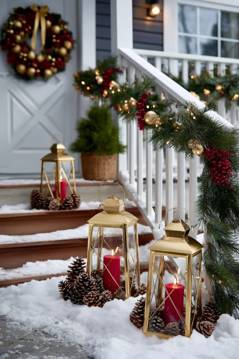 gold lanterns with red candles illuminating snowy steps and pinecone arrangements 1
