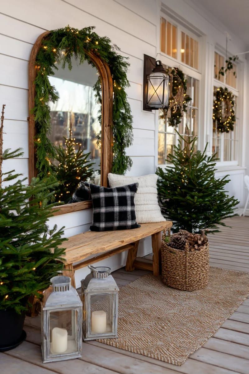 rustic wood-framed mirror reflecting a garland-wrapped front porch chandelier 1