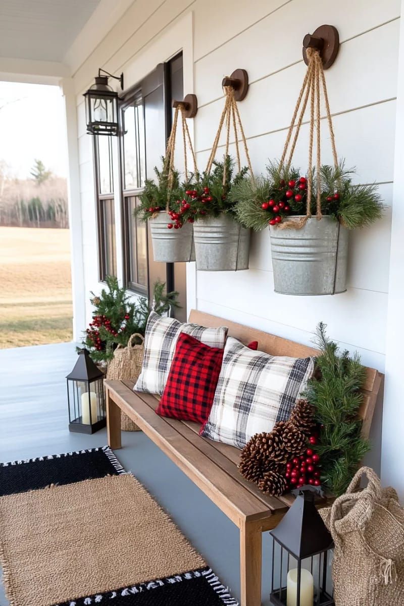hanging galvanized buckets overflowing with evergreen branches and red berries 1